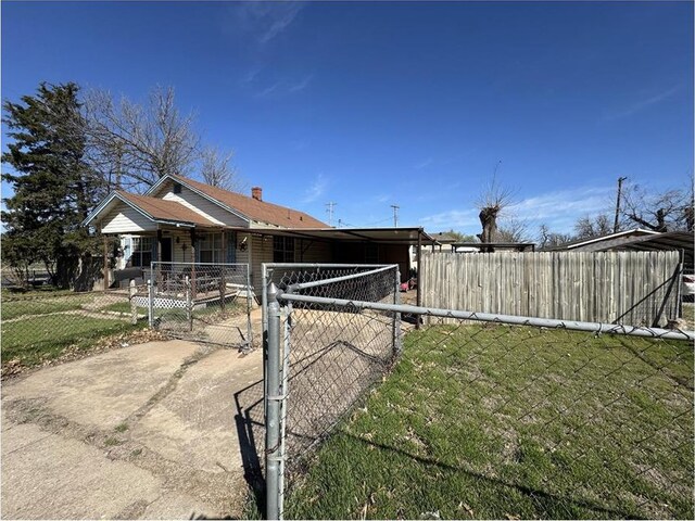 501 SE 15th St, Oklahoma City, OK 73129 - view of home's exterior featuring a lawn, a gate, and fence