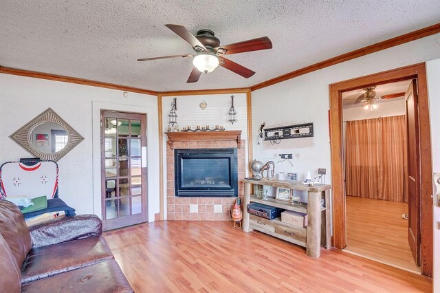 501 SE 15th St, Oklahoma City, OK 73129 - living area featuring a tile fireplace, ceiling fan, ornamental molding, and wood finished floors