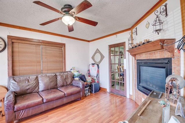 501 SE 15th St, Oklahoma City, OK 73129 - living area with wood finished floors, ornamental molding, a fireplace, a textured ceiling, and ceiling fan
