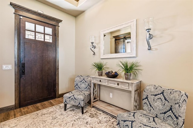 foyer entrance with baseboards and wood finished floors