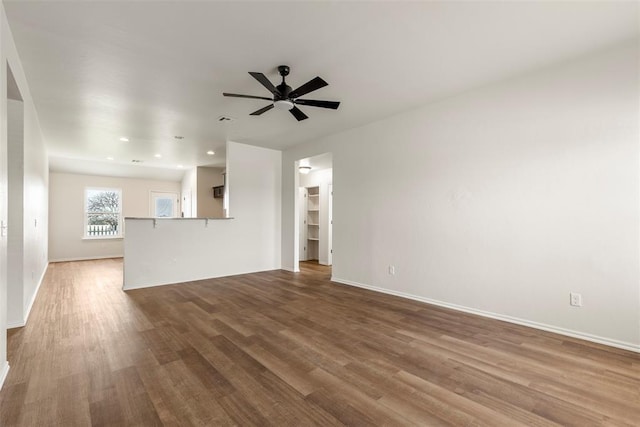 unfurnished living room featuring recessed lighting, baseboards, a ceiling fan, and wood finished floors