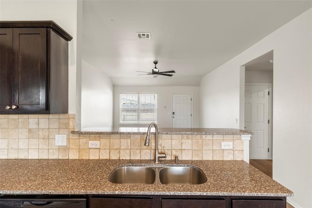 kitchen featuring visible vents, dark brown cabinetry, black dishwasher, a ceiling fan, and a sink