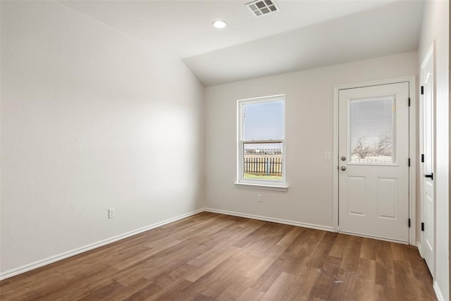 interior space with wood finished floors, visible vents, baseboards, recessed lighting, and vaulted ceiling