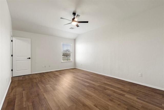 spare room featuring visible vents, a ceiling fan, wood finished floors, baseboards, and vaulted ceiling