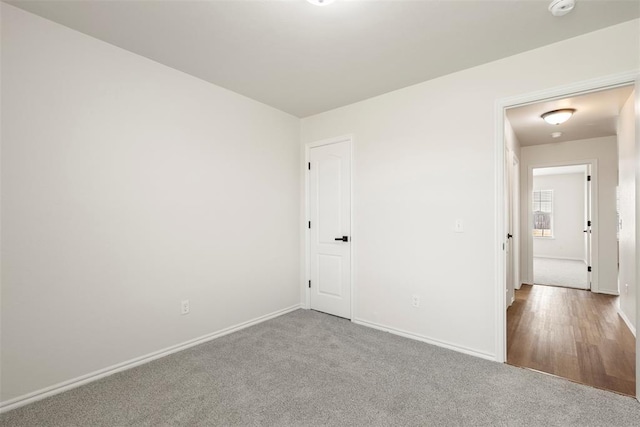 unfurnished room with baseboards and carpet floors