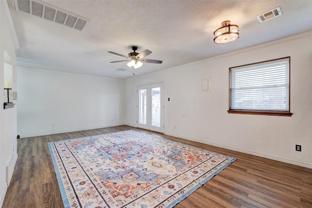 empty room with visible vents, wood finished floors, and a ceiling fan