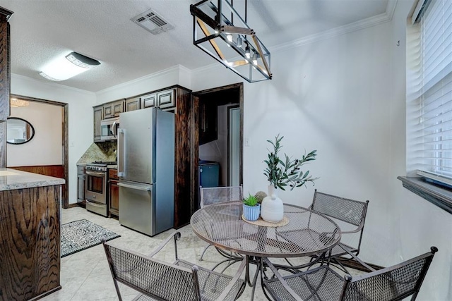 dining room with light tile patterned floors, visible vents, an inviting chandelier, and ornamental molding