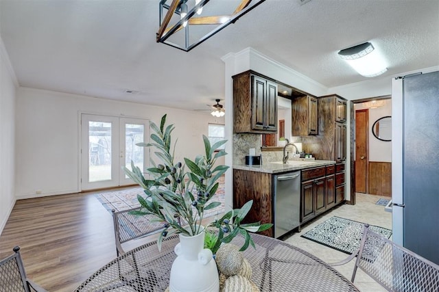 kitchen featuring tasteful backsplash, french doors, dark brown cabinetry, appliances with stainless steel finishes, and light wood finished floors