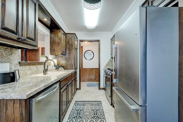 kitchen featuring tasteful backsplash, crown molding, appliances with stainless steel finishes, a textured ceiling, and a sink