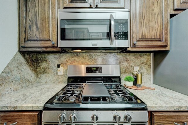 kitchen featuring backsplash, appliances with stainless steel finishes, and light countertops