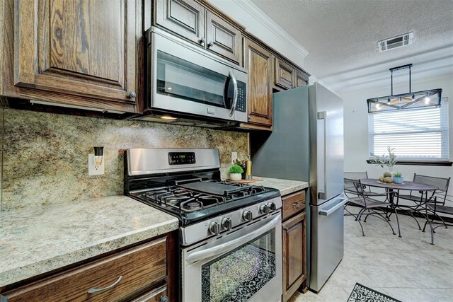 kitchen with visible vents, light countertops, appliances with stainless steel finishes, a textured ceiling, and backsplash