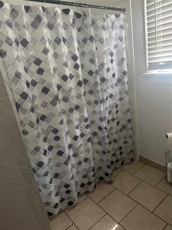 118 NE 2nd St, Moore, OK 73160 - full bath featuring curtained shower and tile patterned flooring