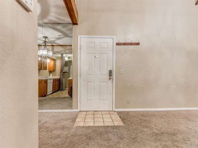 entryway featuring beamed ceiling, a textured wall, baseboards, and light carpet