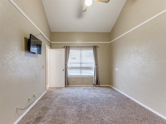 empty room with carpet flooring, baseboards, ceiling fan, and a textured wall