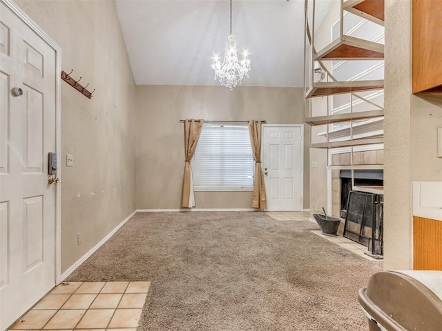 carpeted entrance foyer with a fireplace, baseboards, and an inviting chandelier