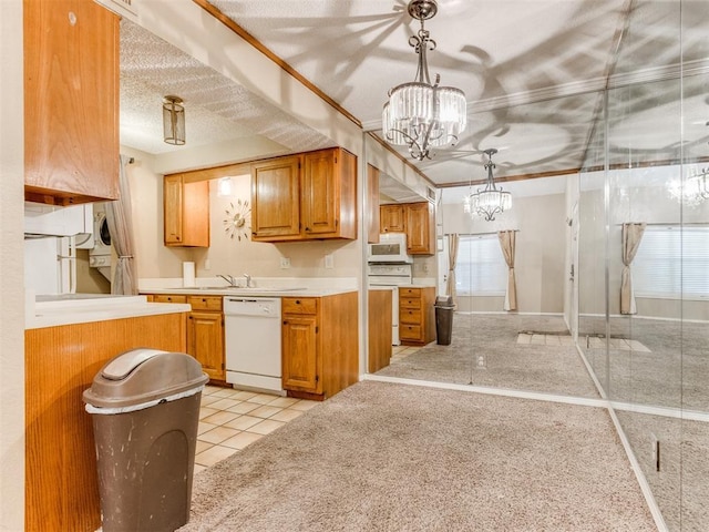 kitchen featuring white appliances, hanging light fixtures, light countertops, a textured ceiling, and a notable chandelier