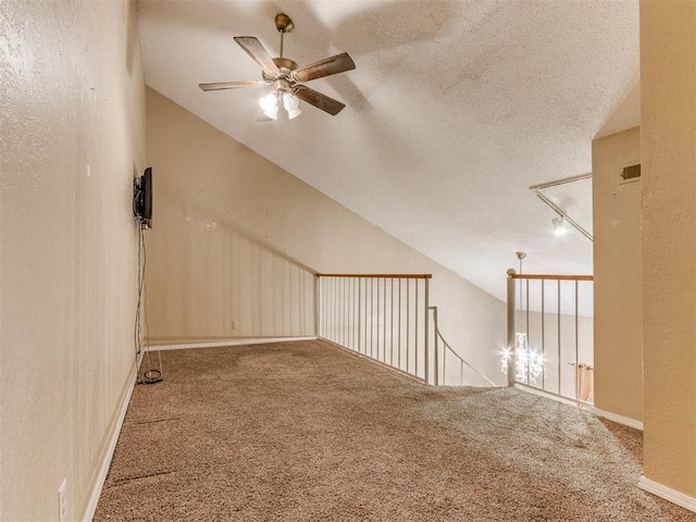 additional living space with carpet floors, a textured ceiling, ceiling fan, and vaulted ceiling