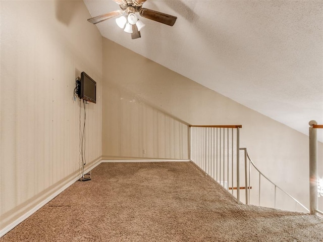 bonus room featuring lofted ceiling, a textured ceiling, ceiling fan, and carpet flooring