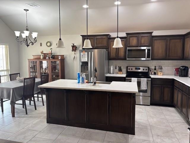 kitchen with light countertops, an inviting chandelier, stainless steel appliances, a sink, and visible vents
