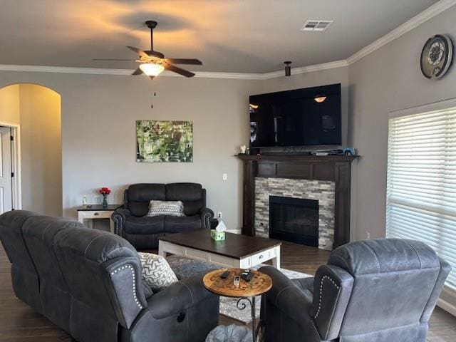 living area featuring visible vents, arched walkways, ornamental molding, and a ceiling fan
