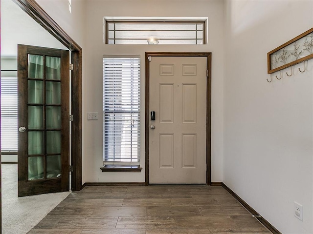 entryway with baseboards and wood finished floors