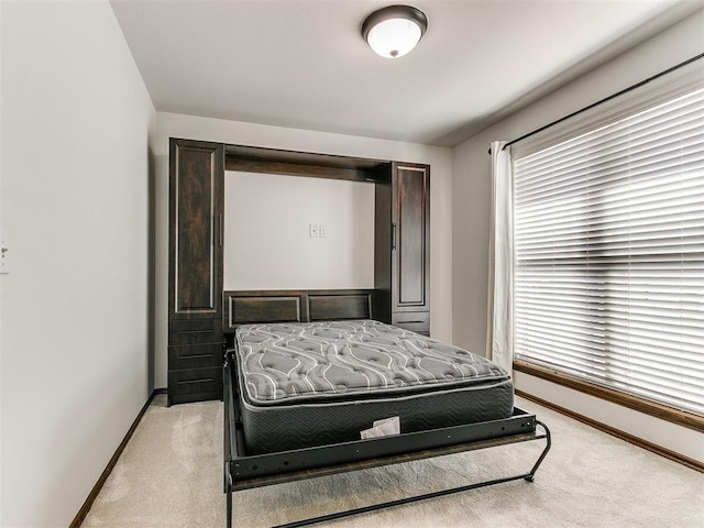 bedroom featuring baseboards and light carpet