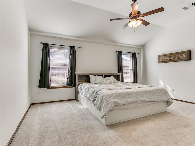 carpeted bedroom with visible vents, baseboards, lofted ceiling, and a ceiling fan