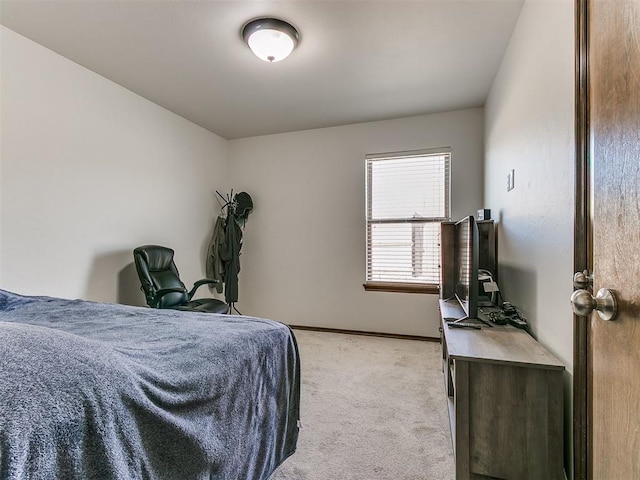 bedroom with light colored carpet and baseboards