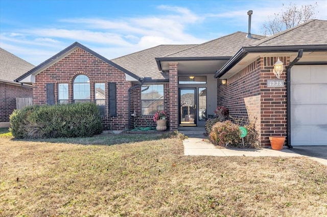 single story home with a front yard, brick siding, and roof with shingles