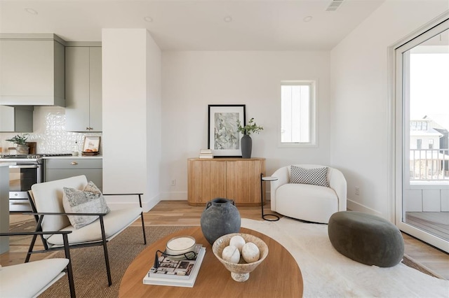 sitting room featuring baseboards and light wood finished floors