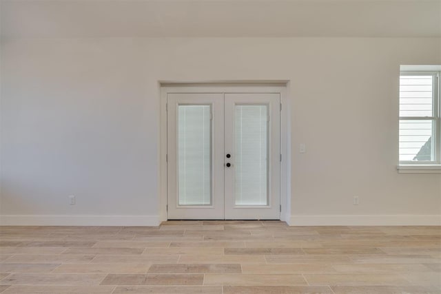 interior space with french doors, baseboards, and light wood-style floors