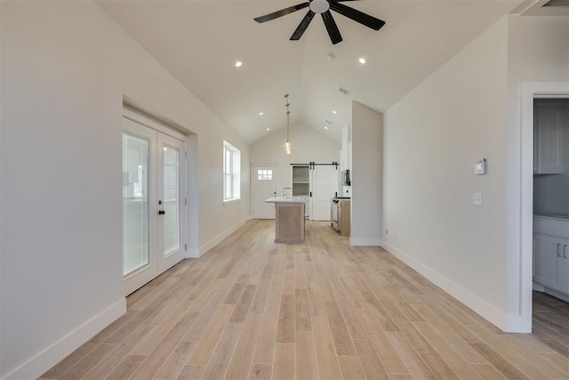 kitchen featuring a center island, open floor plan, light countertops, light wood-style floors, and a ceiling fan