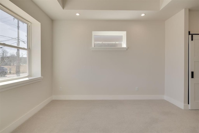 unfurnished room featuring a wealth of natural light, recessed lighting, and light carpet