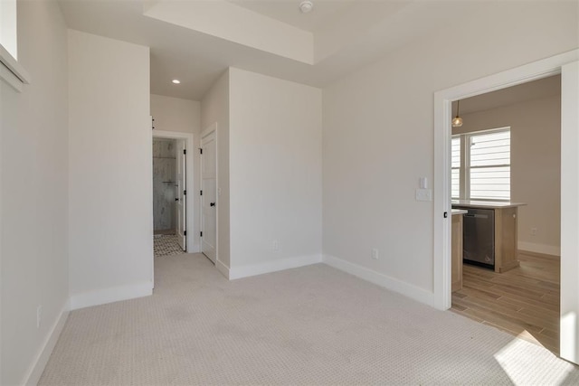 spare room featuring recessed lighting, baseboards, and light colored carpet