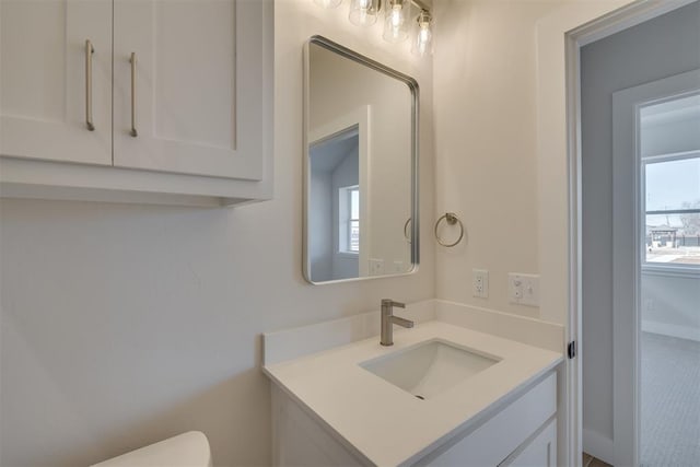 bathroom with plenty of natural light, toilet, and vanity