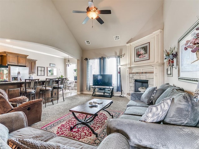 living area featuring high vaulted ceiling, visible vents, and light carpet