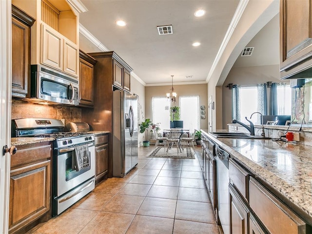 kitchen with visible vents, ornamental molding, a notable chandelier, stainless steel appliances, and a sink