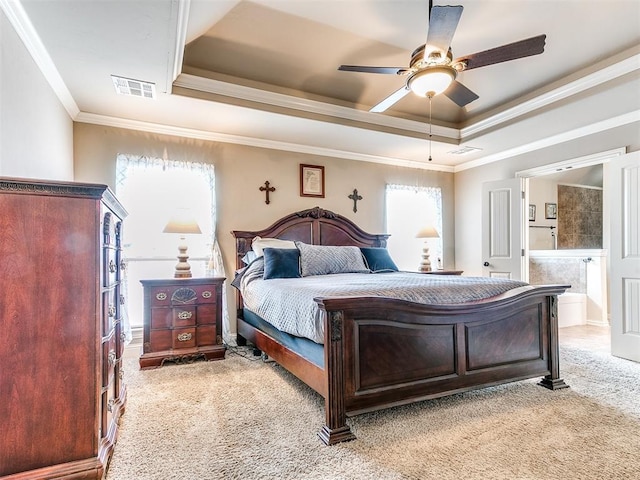 bedroom featuring visible vents, ornamental molding, light carpet, ensuite bath, and a raised ceiling