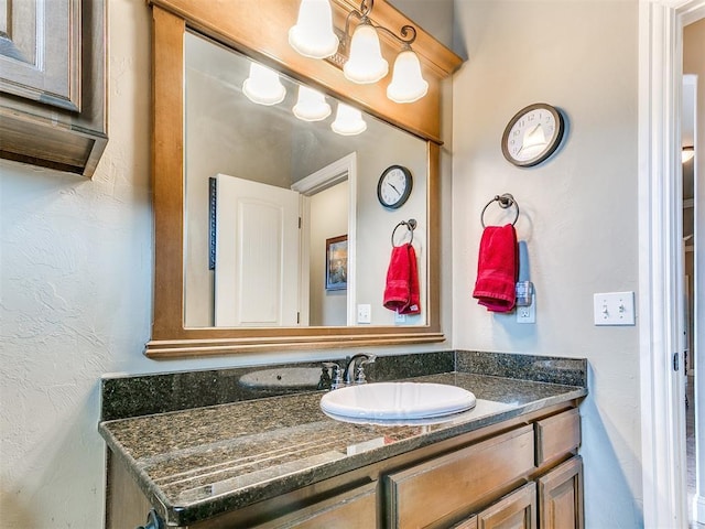 bathroom featuring vanity and a textured wall