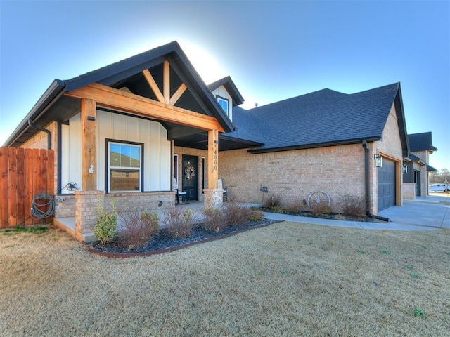 view of front of house featuring driveway, a shingled roof, a front lawn, a garage, and board and batten siding