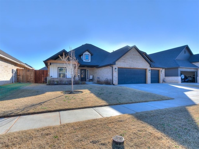 view of front of property featuring a front yard, fence, roof with shingles, concrete driveway, and a garage