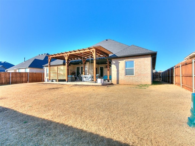 rear view of property featuring a patio, brick siding, a fenced backyard, and a pergola