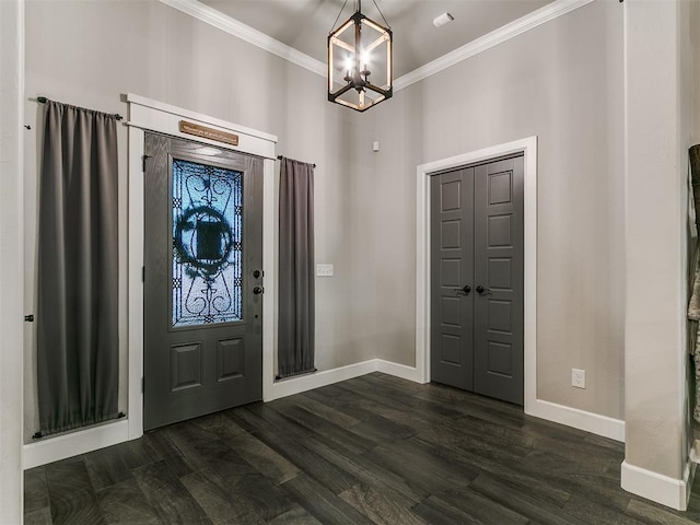 entrance foyer featuring dark wood finished floors, baseboards, an inviting chandelier, and ornamental molding