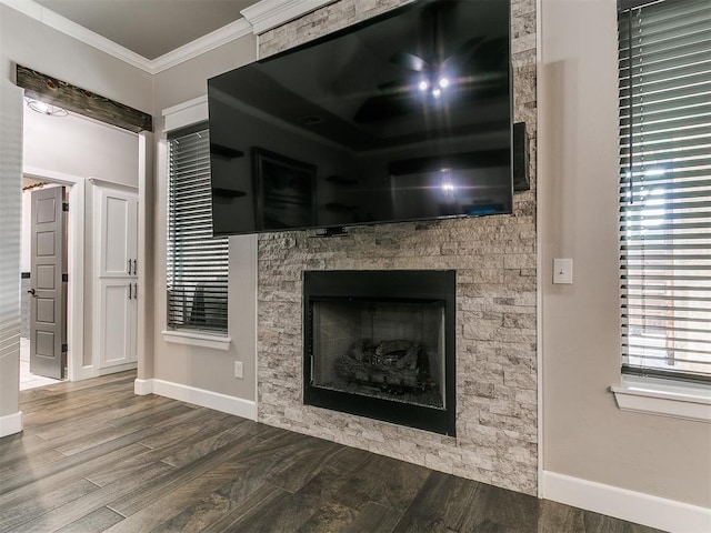 unfurnished living room with baseboards, wood finished floors, ornamental molding, and a fireplace