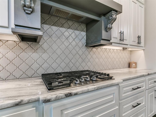 kitchen with stainless steel gas cooktop, backsplash, light countertops, and extractor fan