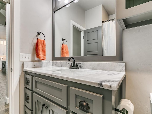 full bathroom featuring wood finished floors and vanity