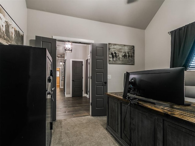 office area featuring carpet floors, lofted ceiling, and wood finished floors