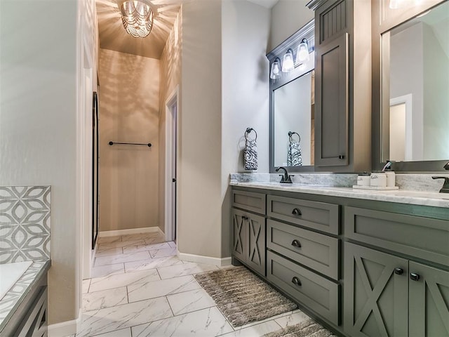 bathroom with double vanity, marble finish floor, baseboards, and a sink