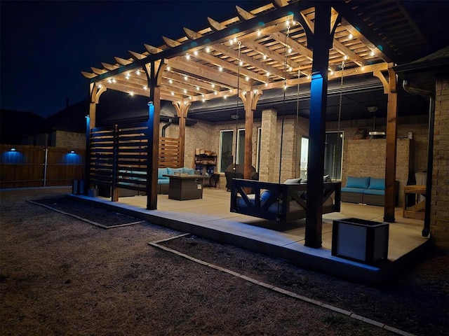 patio at night with an outdoor living space, a pergola, and fence