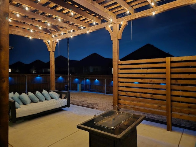 patio at twilight with fence and a pergola